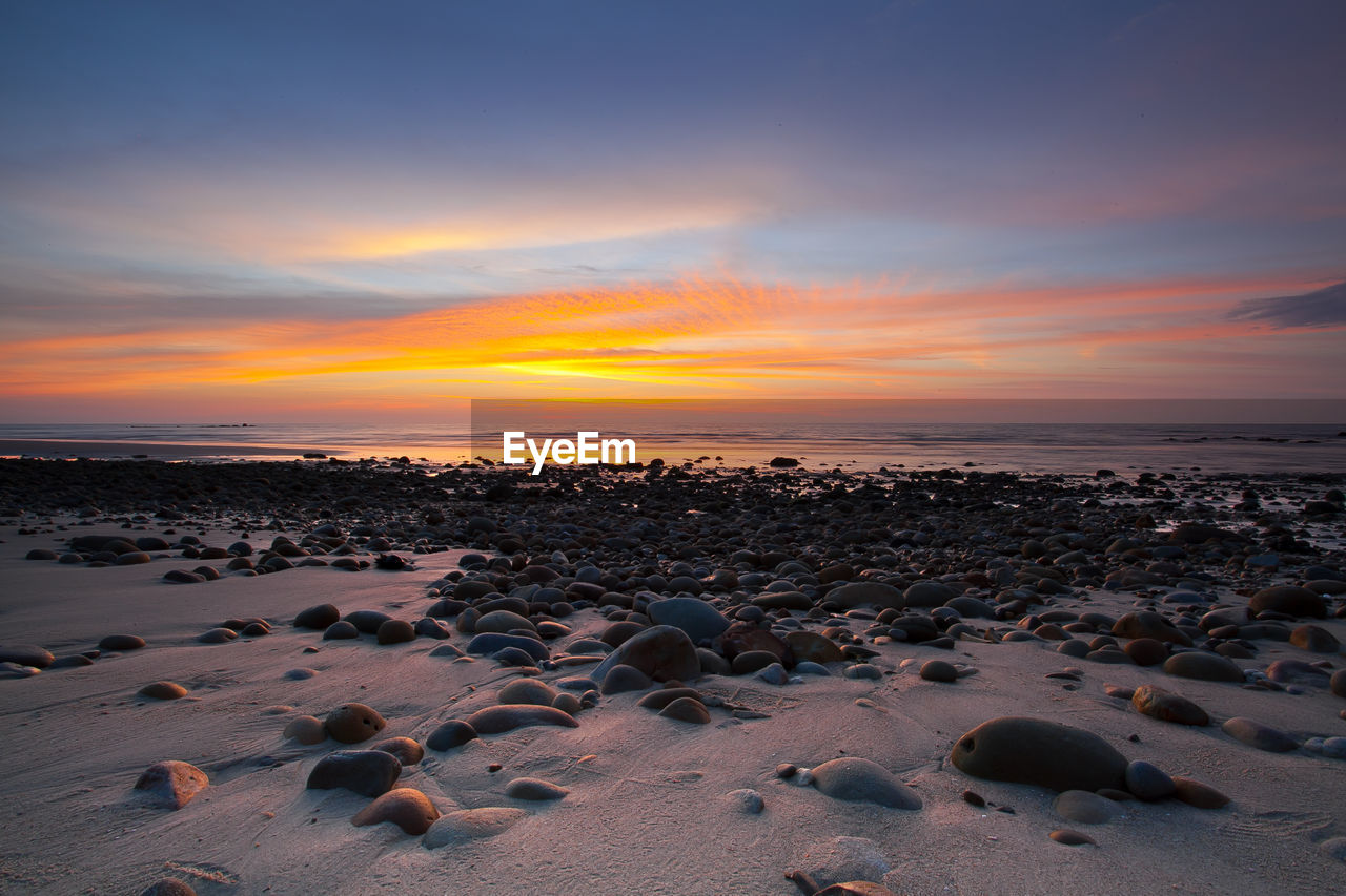 Scenic view of beach against sky during sunset