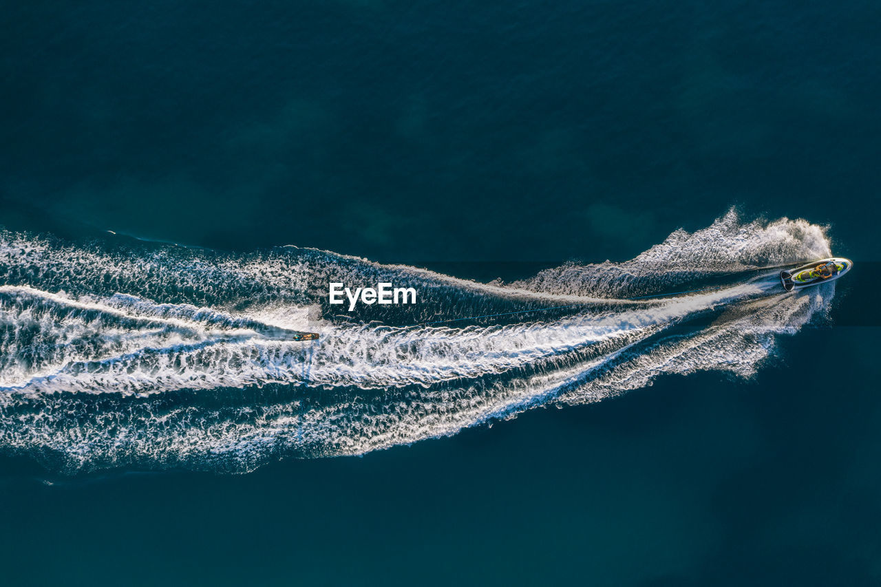 Aerial view of people jet boating in sea