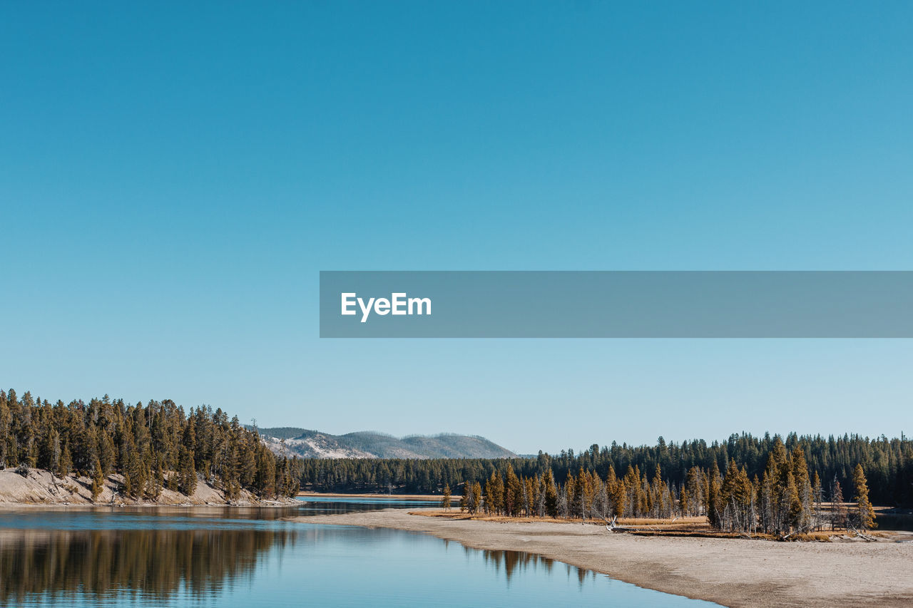 Scenic view of lake against clear blue sky