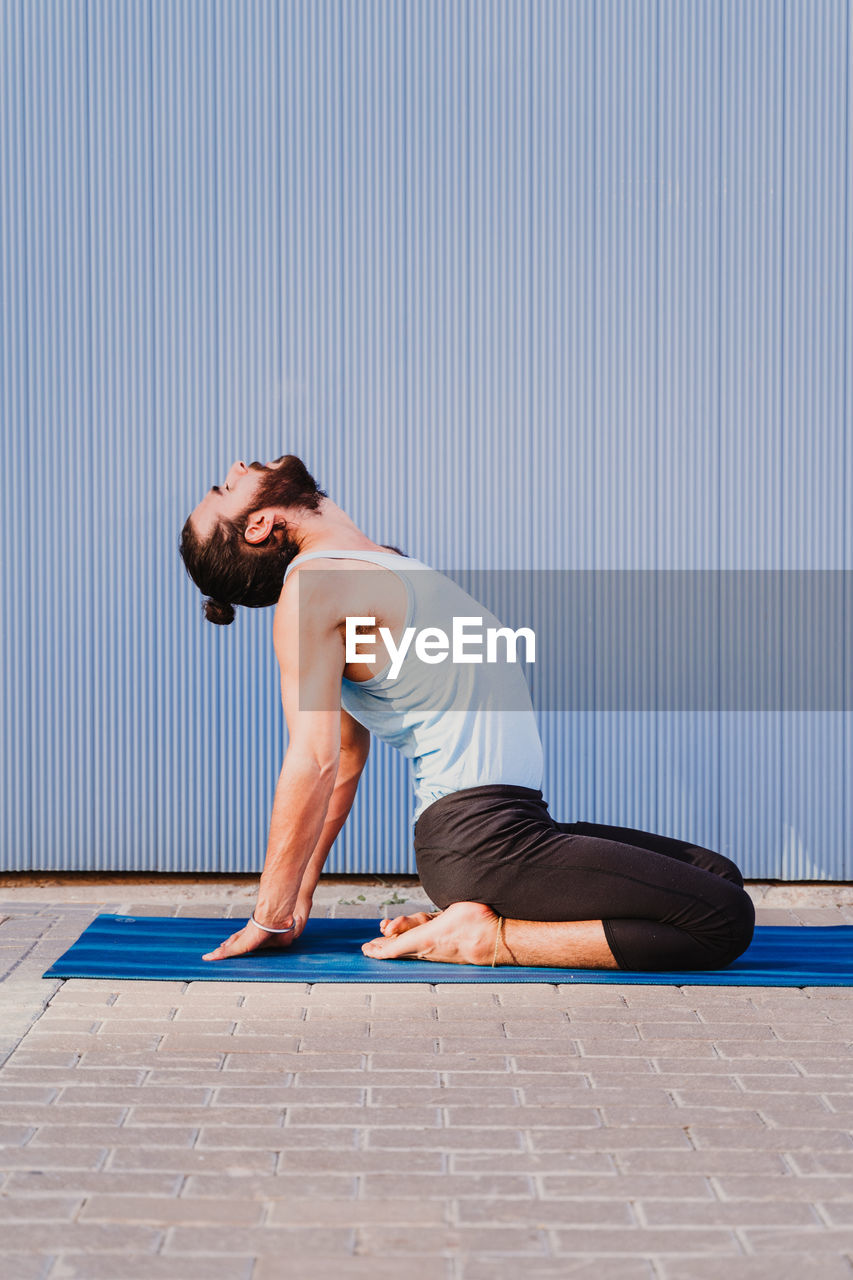 Side view of man doing yoga