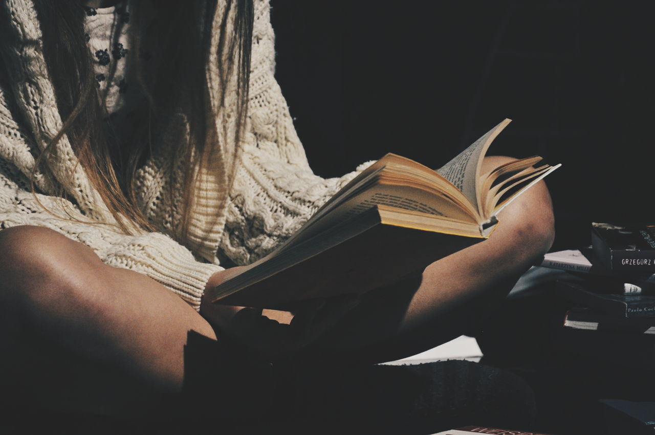 Midsection of woman reading book