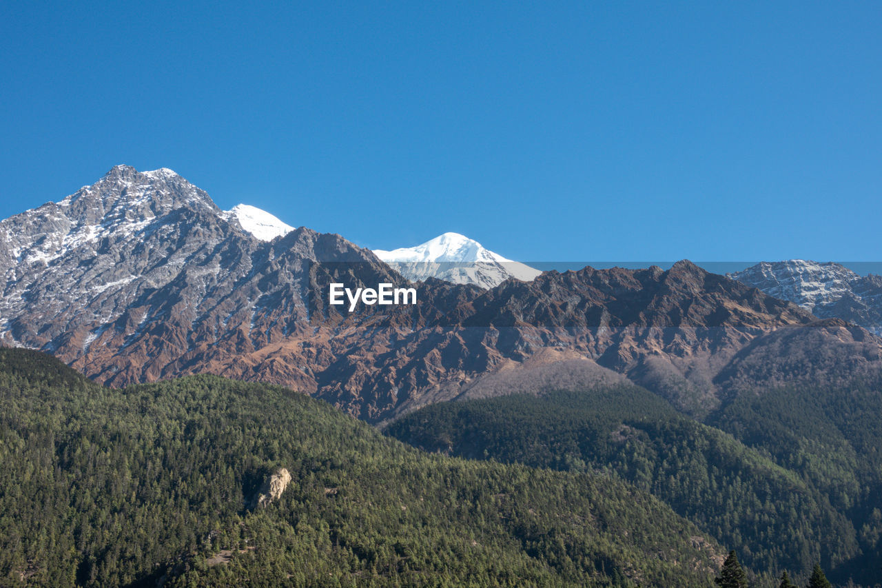 Scenic view of mountains against clear blue sky