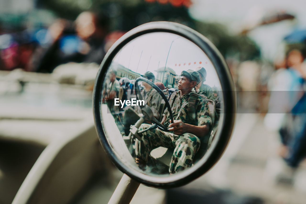 Reflection of man on bicycle wheel