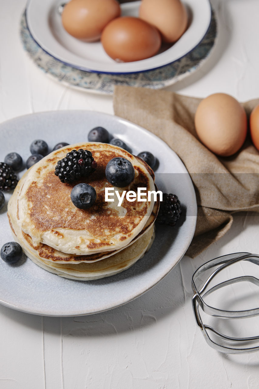 Stack of pancakes with berries, still life overhead shot.