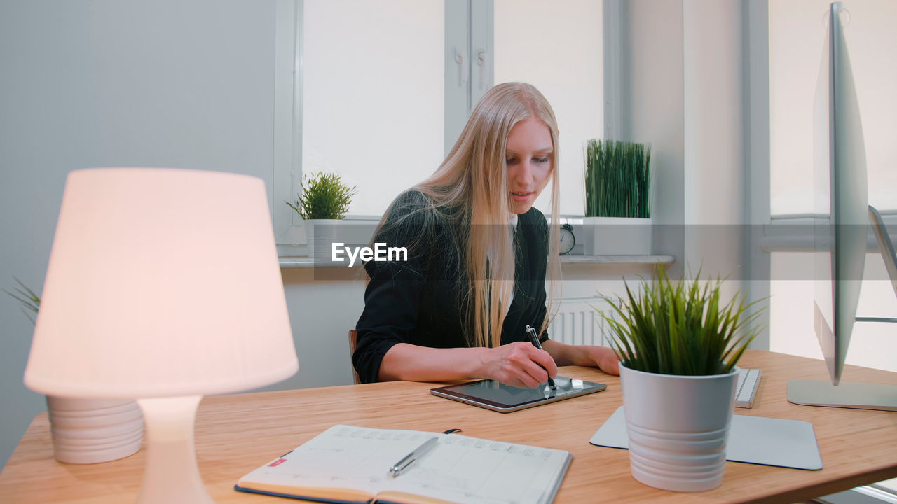 Woman using graphic tablet at table