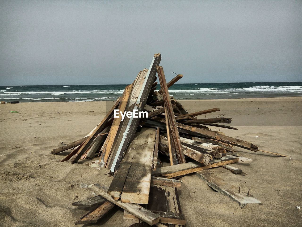 THATCHED ROOF AT BEACH AGAINST SKY