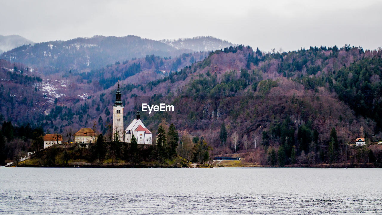 Scenic view of lake and buildings against sky