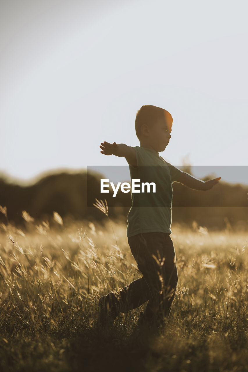 Full length of boy playing on grassy field