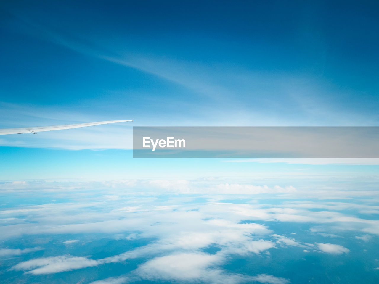 AERIAL VIEW OF AIRCRAFT WING AGAINST SKY