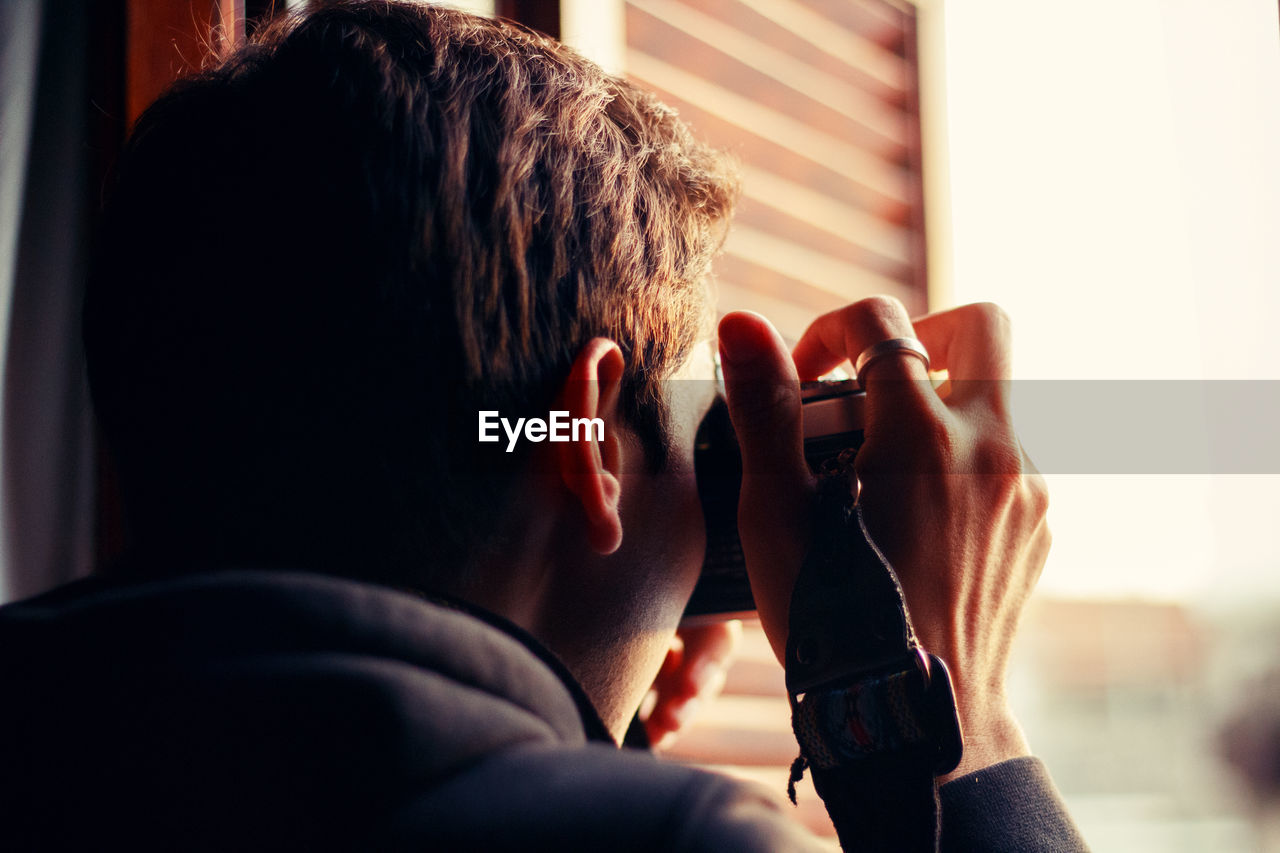 Rear view of man photographing