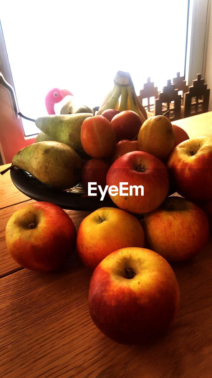 CLOSE-UP OF FRUITS IN PLATE ON TABLE