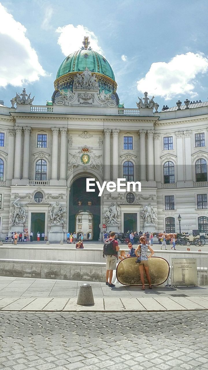 Tourist visiting hofburg palace against sky