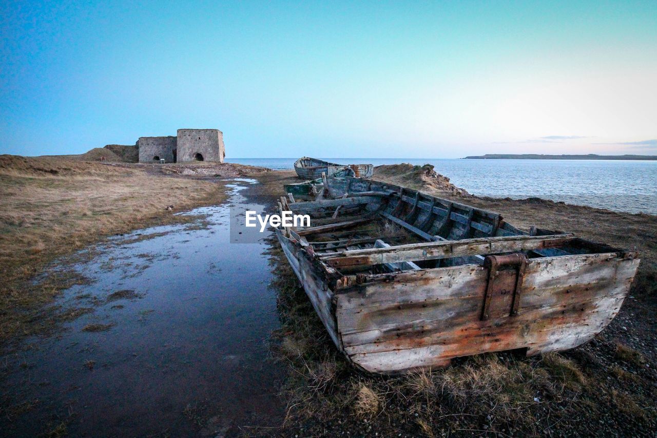 Abandoned boat at sea shore