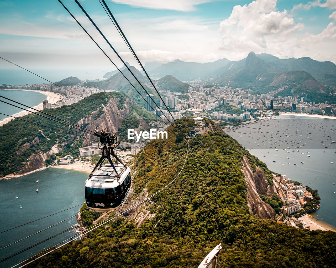 HIGH ANGLE VIEW OF OVERHEAD CABLE CAR OVER MOUNTAINS