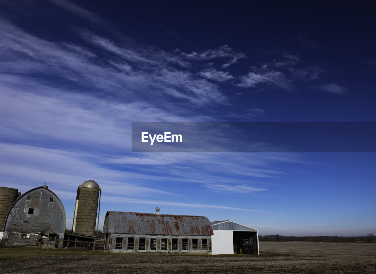 Abandoned building in field against sky