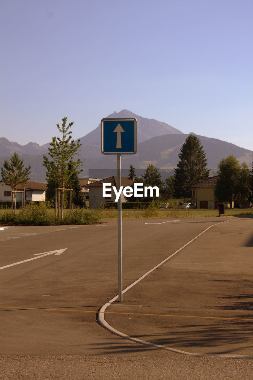 ROAD SIGN BY STREET AGAINST SKY