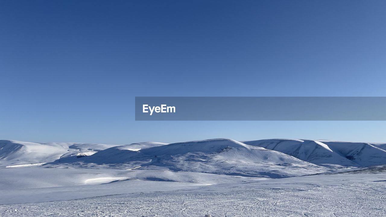 Scenic view of snowcapped mountains against clear blue sky - svalbard 