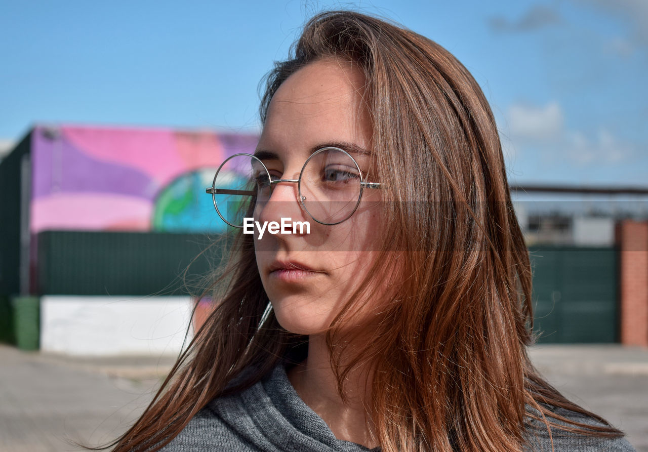 Teenage girl wearing eyeglasses standing on playing field