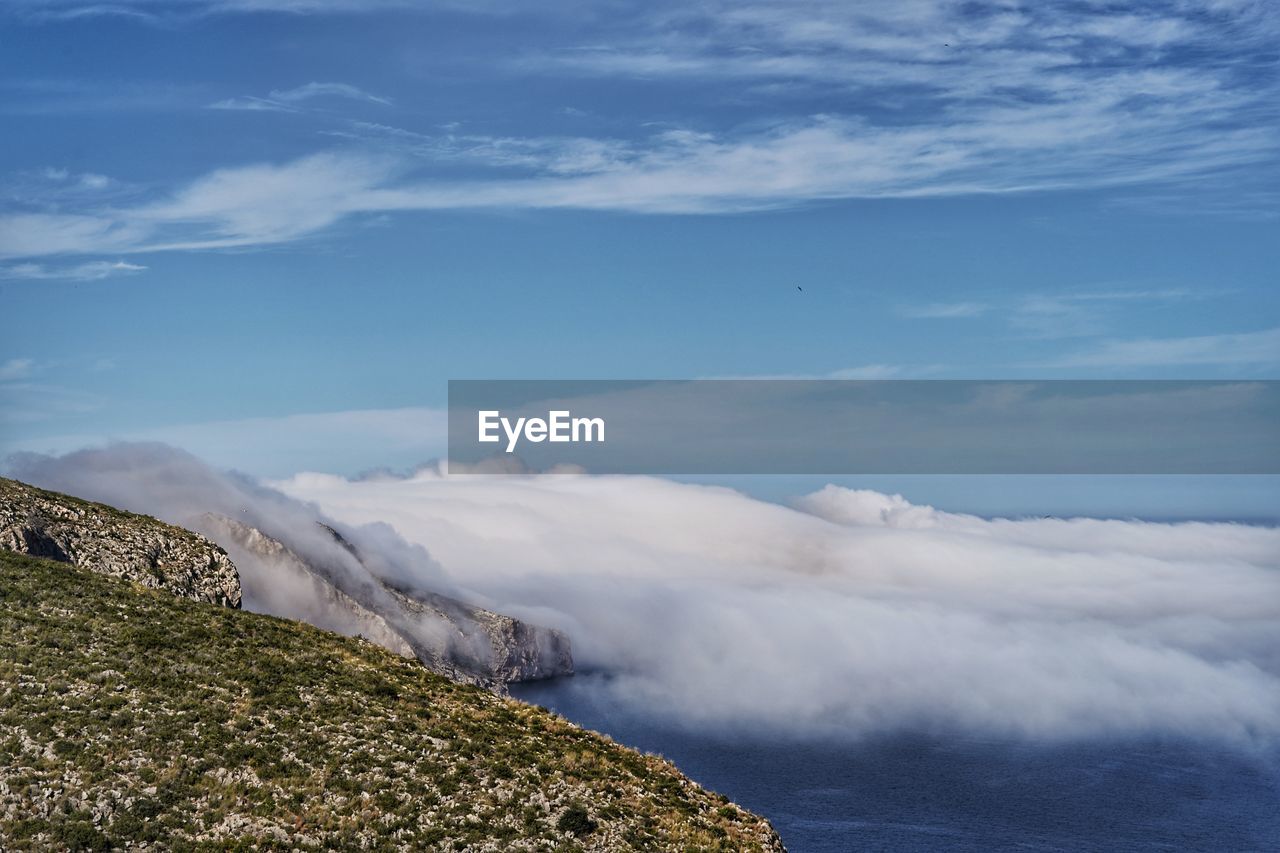 Scenic view of sea and mountains against sky