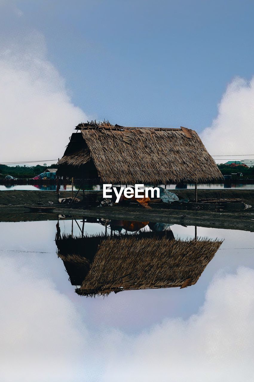 BUILT STRUCTURE BY LAKE AGAINST SKY IN BACKGROUND