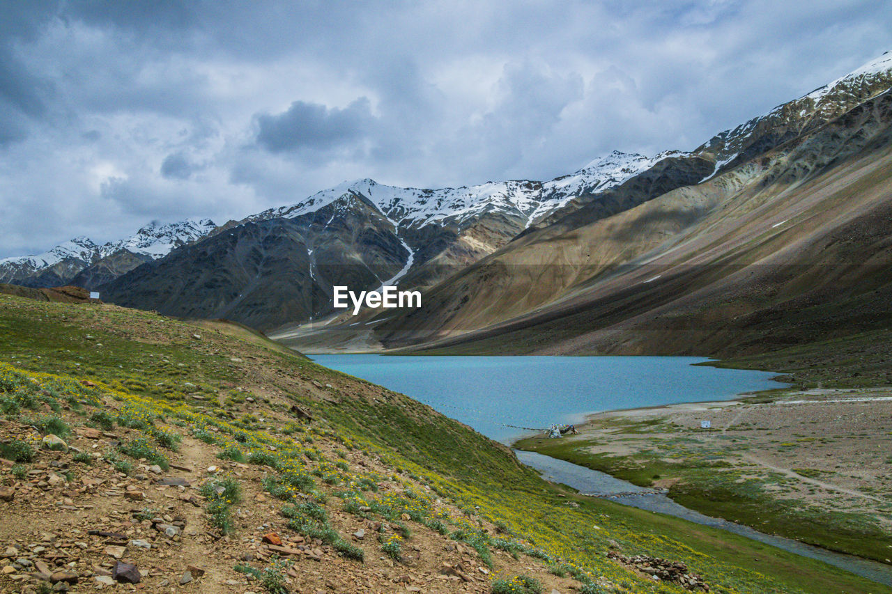 SCENIC VIEW OF LAKE BY MOUNTAIN AGAINST SKY