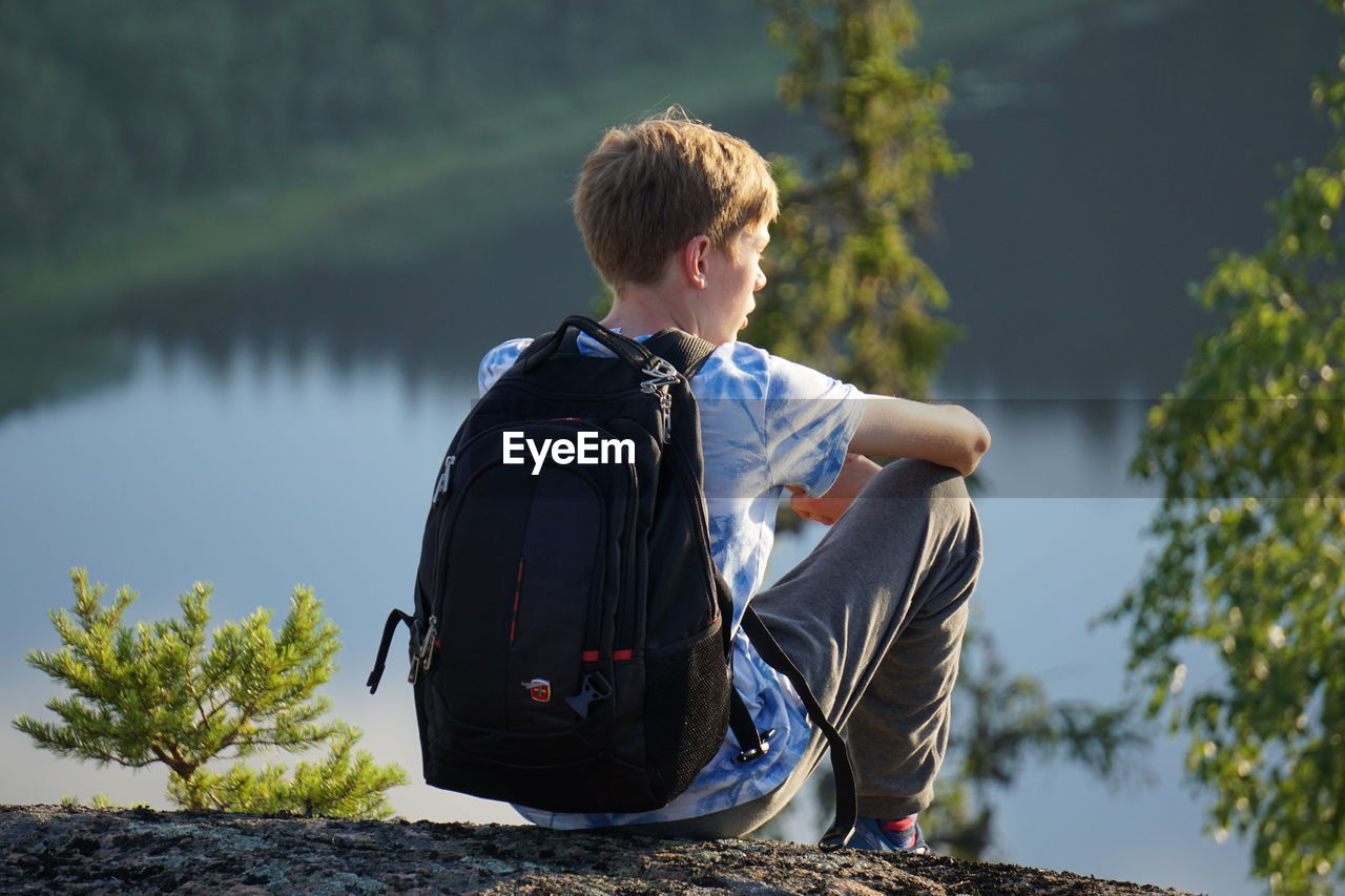 BOY SITTING BY TREE