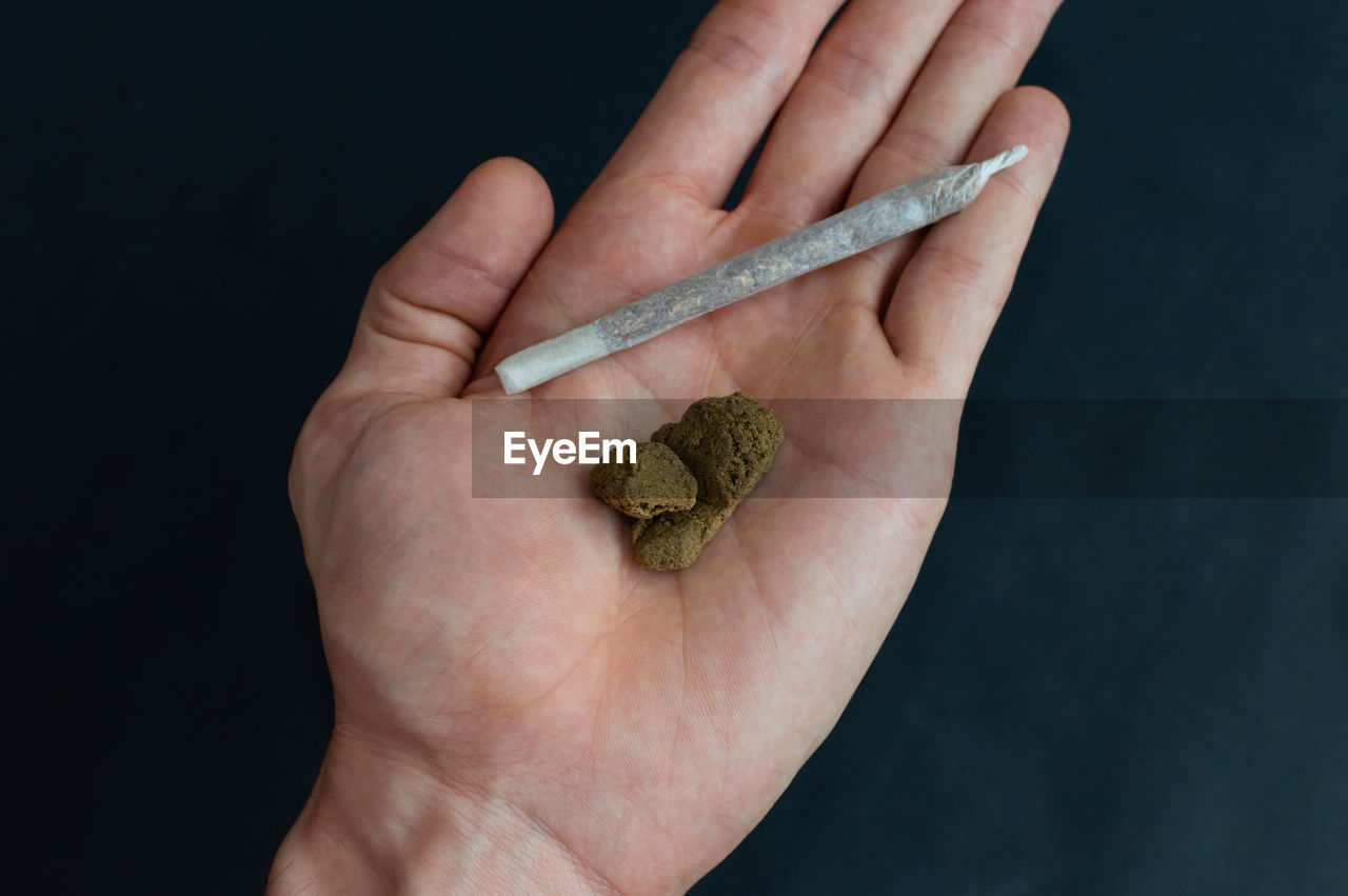 CLOSE-UP OF PERSON HAND HOLDING CIGARETTE