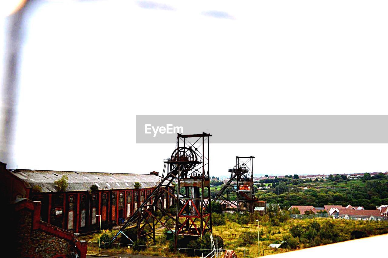 Colliery by historic building against sky