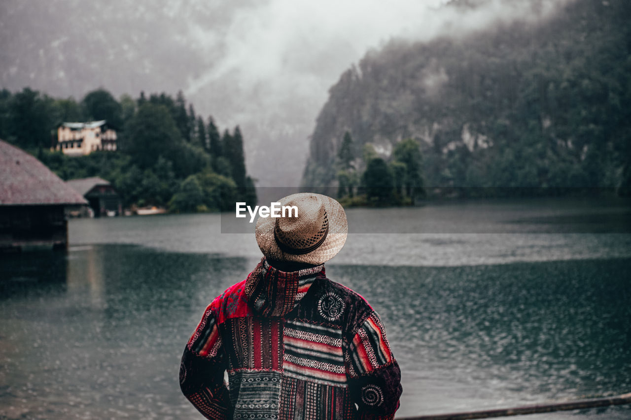 Rear view of man standing by river