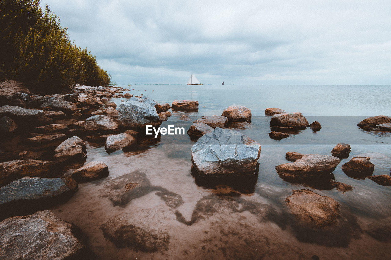 Rocks in sea against sky