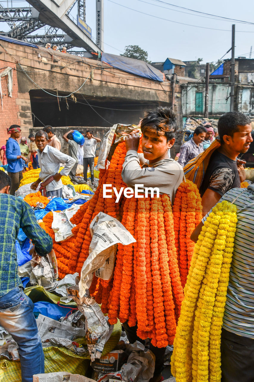 REAR VIEW OF PEOPLE AT MARKET