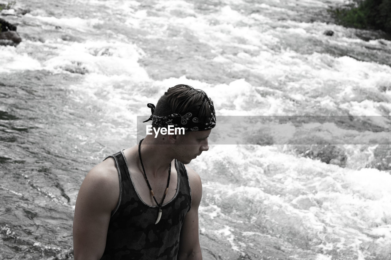 High angle view of man looking away while standing by river