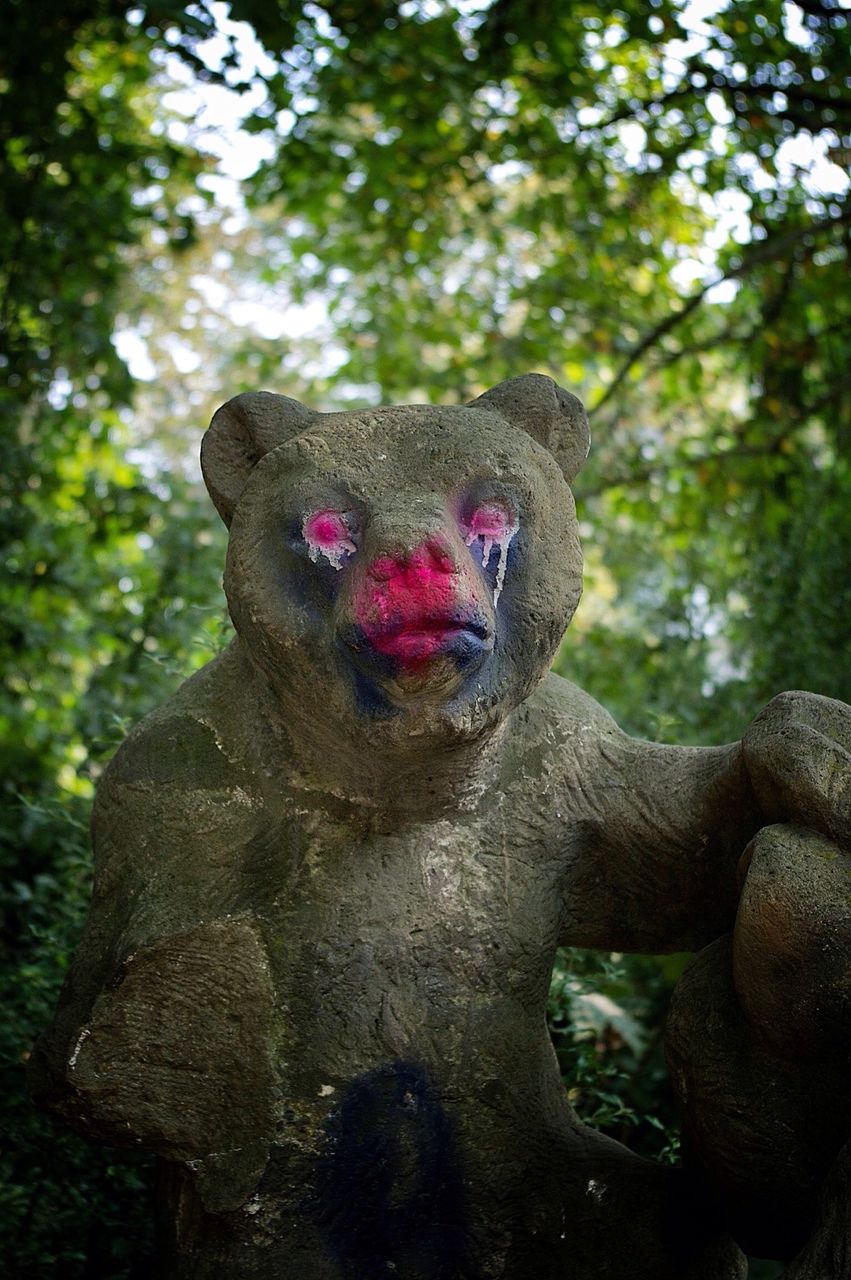 Statue of bear with painted red eyes and nose