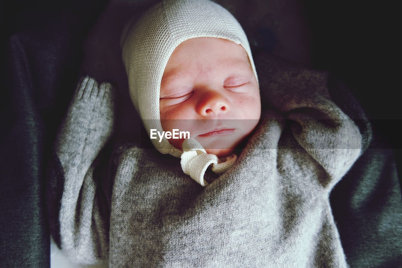 Close-up of cute baby boy sleeping on bed