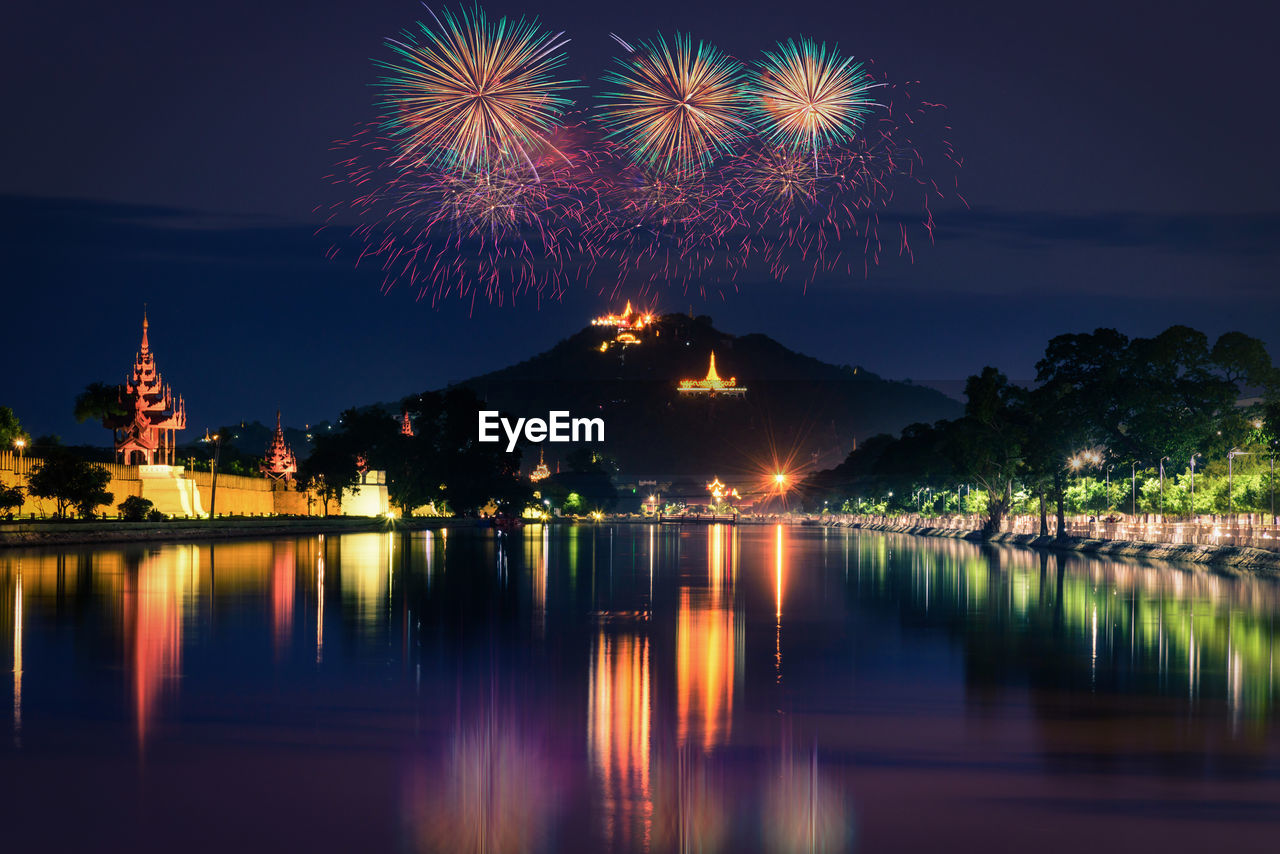 FIREWORK DISPLAY OVER LAKE AGAINST SKY