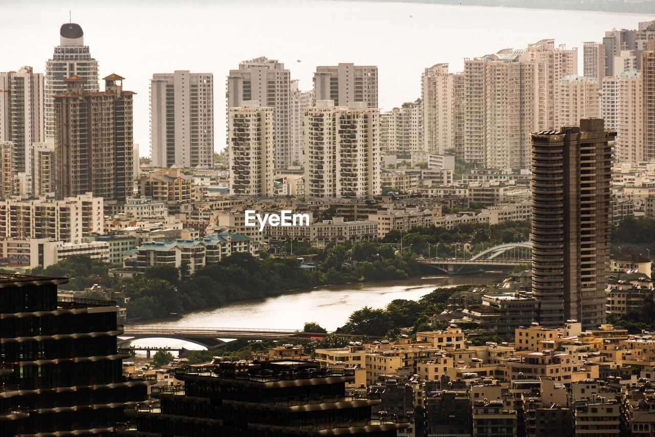 High angle view of buildings by river against sky