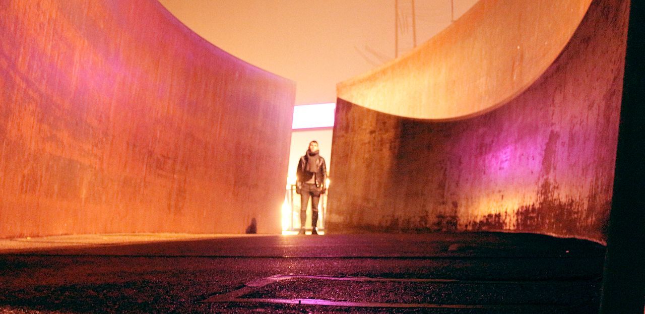 PEOPLE STANDING AT ILLUMINATED STAGE