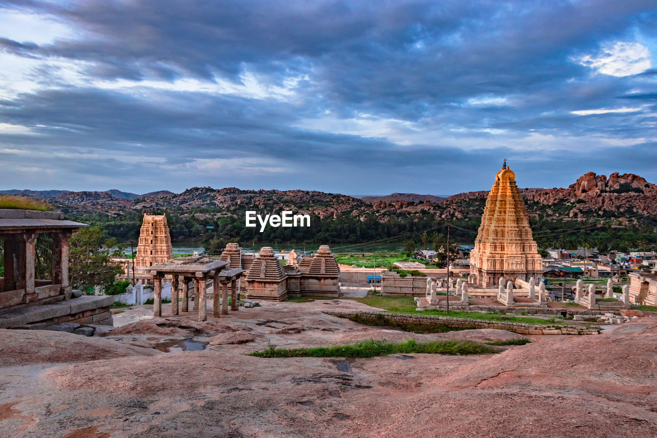 Hampi ruins ancient stone art with dramatic sky flat angle shot