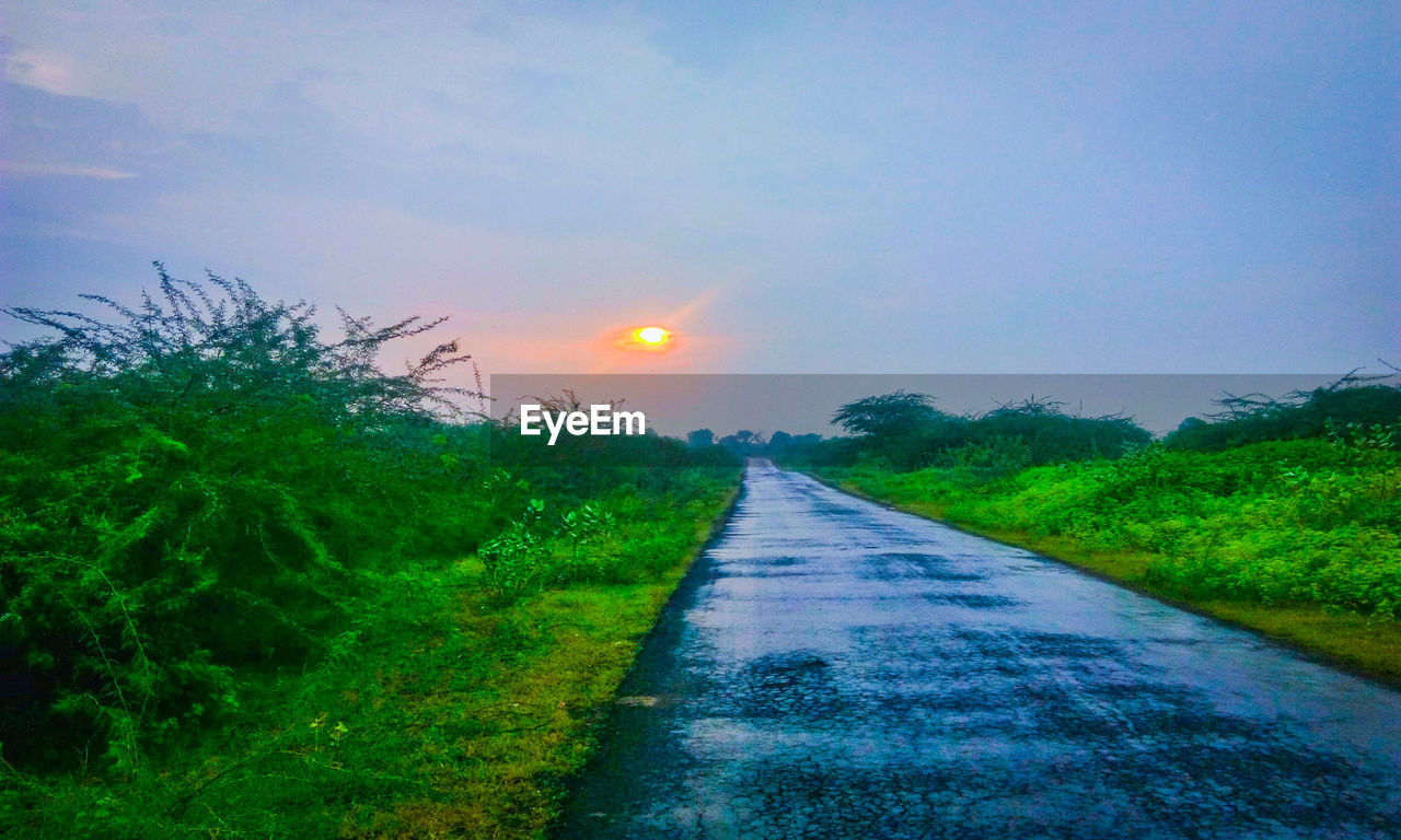 SCENIC VIEW OF FARM AGAINST SKY AT SUNSET