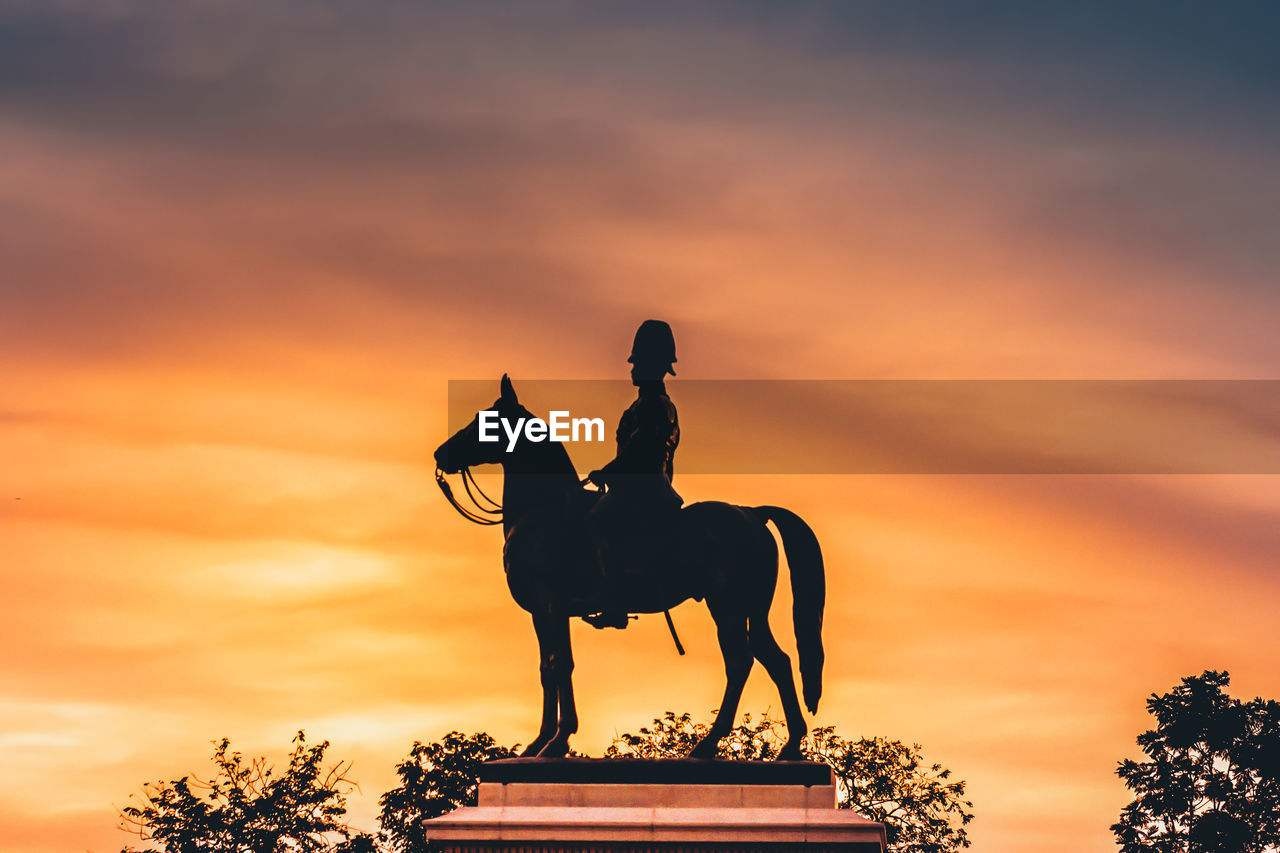 The equestrian statue of king chulalongkorn rama 5 riding horse over nature sunset sky background.