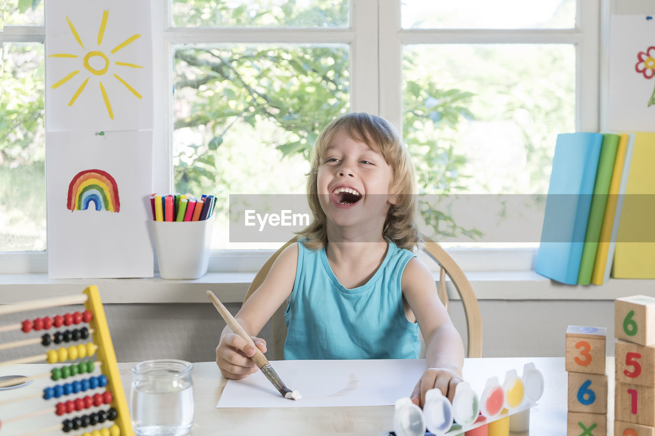 Portrait of happy girl sitting on table