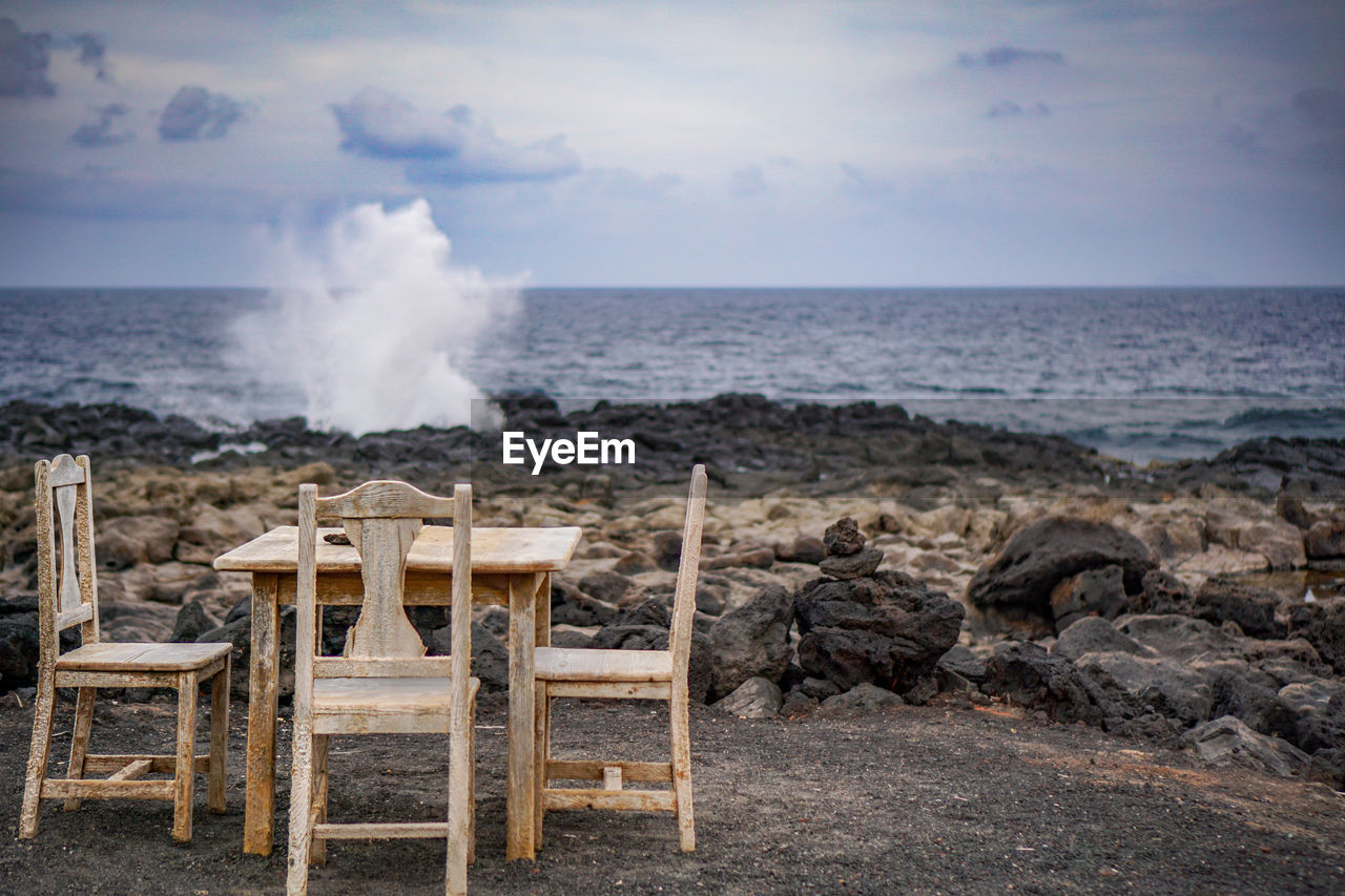 sea, water, sky, ocean, beach, horizon over water, shore, horizon, land, nature, coast, body of water, beauty in nature, cloud, chair, motion, scenics - nature, wave, vacation, seat, no people, rock, outdoors, table, furniture, power in nature, day, travel destinations, seascape, environment, heat, smoke, coastline, wood, tranquility