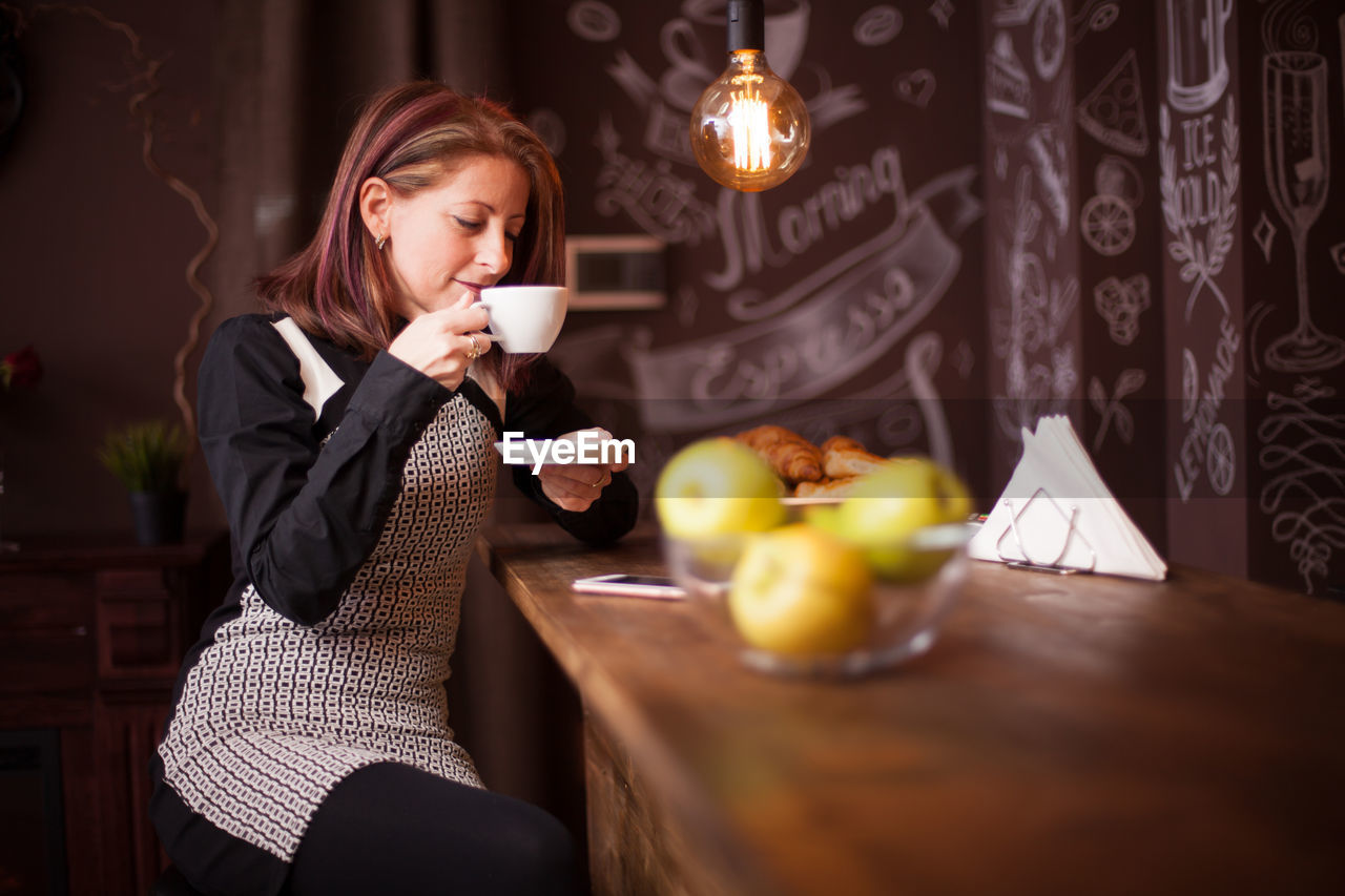 portrait of young woman having breakfast at home