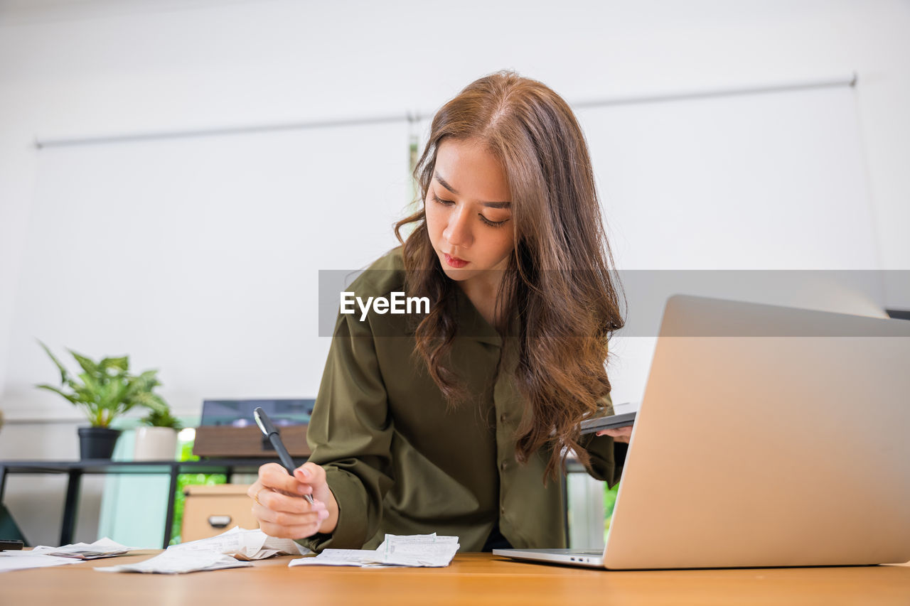 businesswoman using laptop while sitting at home