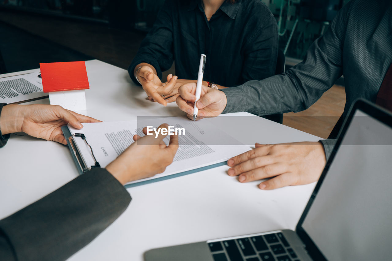 High angle view of man signing documents while sitting at table