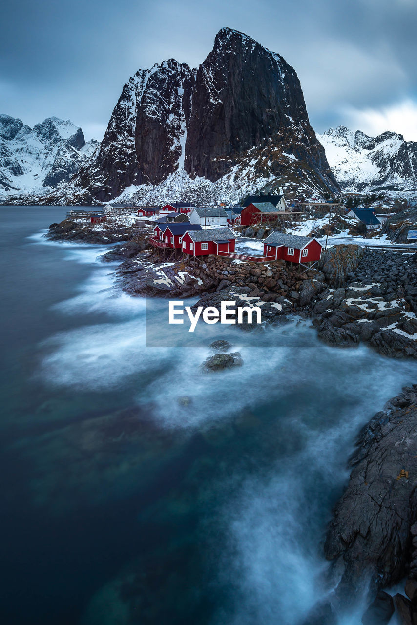 Scenic view of snowcapped mountains by sea against sky