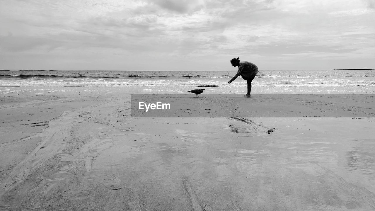 beach, land, water, sea, sky, ocean, wave, shore, sand, nature, coast, one person, white, black and white, full length, cloud, horizon over water, men, horizon, beauty in nature, monochrome, body of water, monochrome photography, leisure activity, motion, holiday, day, scenics - nature, adult, lifestyles, vacation, wind wave, trip, black, outdoors, sports, tranquility, animal, silhouette, person