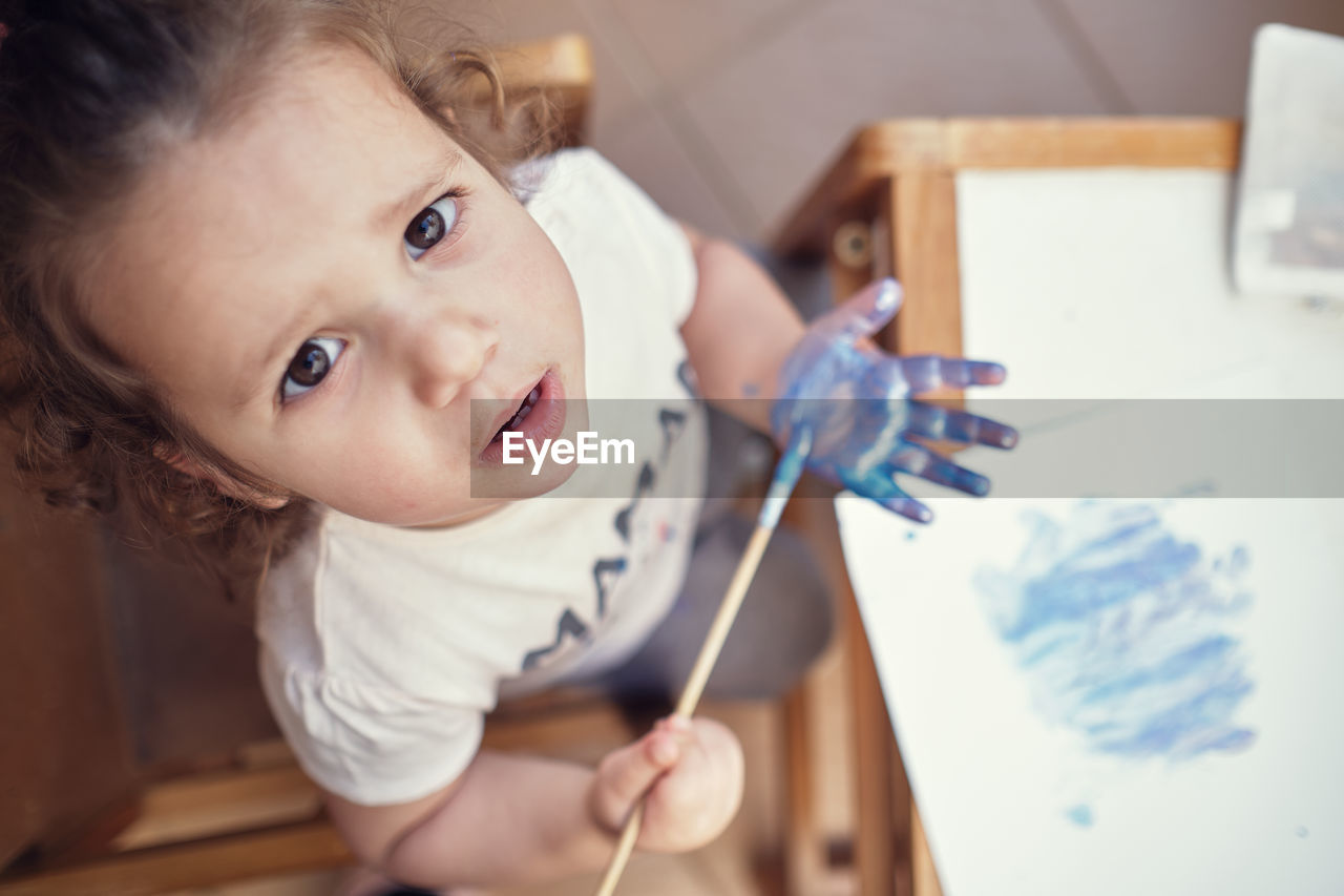 Children playing in an inner courtyard and painting with water paints