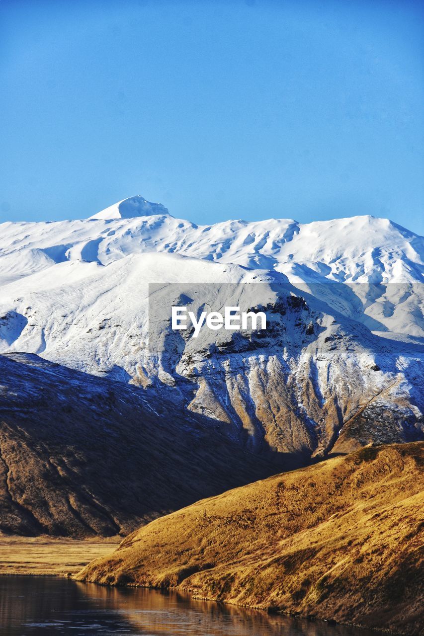 Scenic view of snowcapped mountains against clear sky