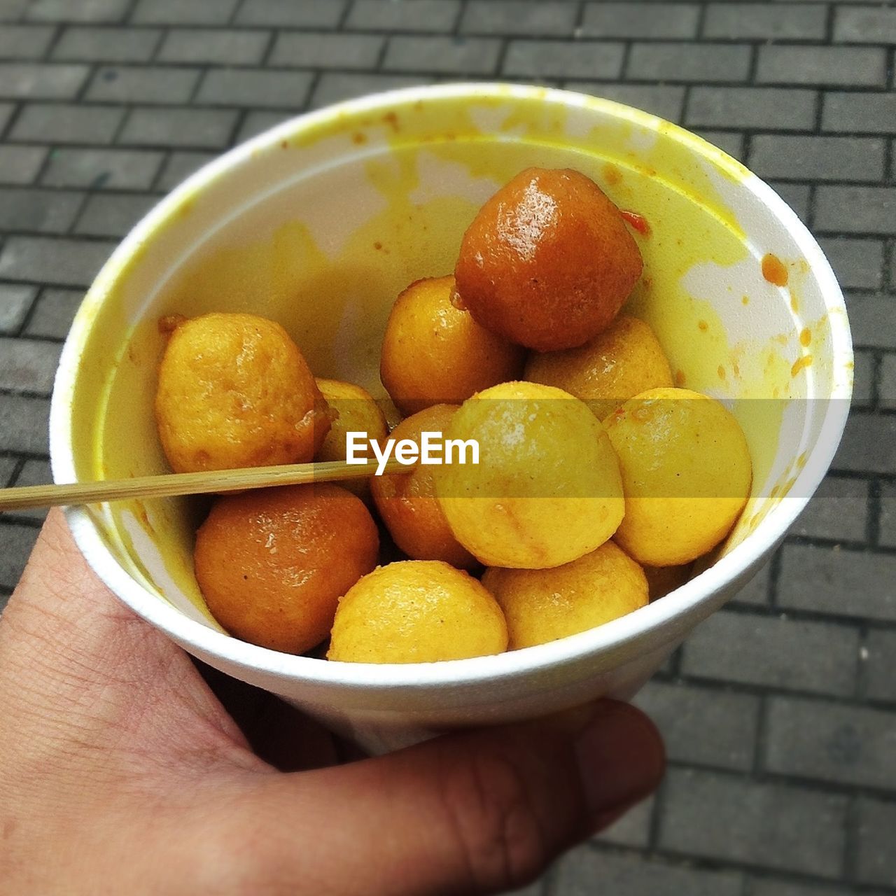 Close-up of hand holding snacks in bowl